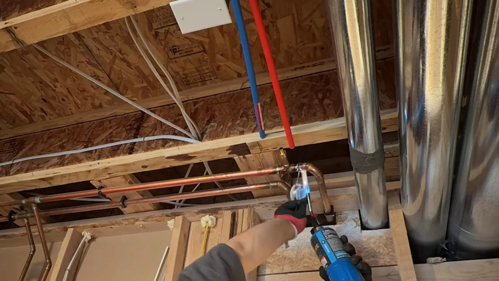 Close-up of framed basement wall with utility sink pipes for a basement and crawlspace plumbing project near Brighton